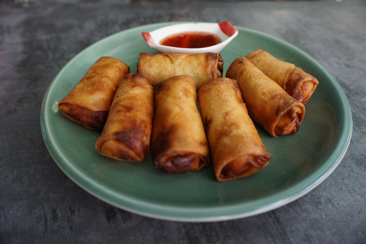 Homemade egg rolls on a plate with sweet and sour sauce